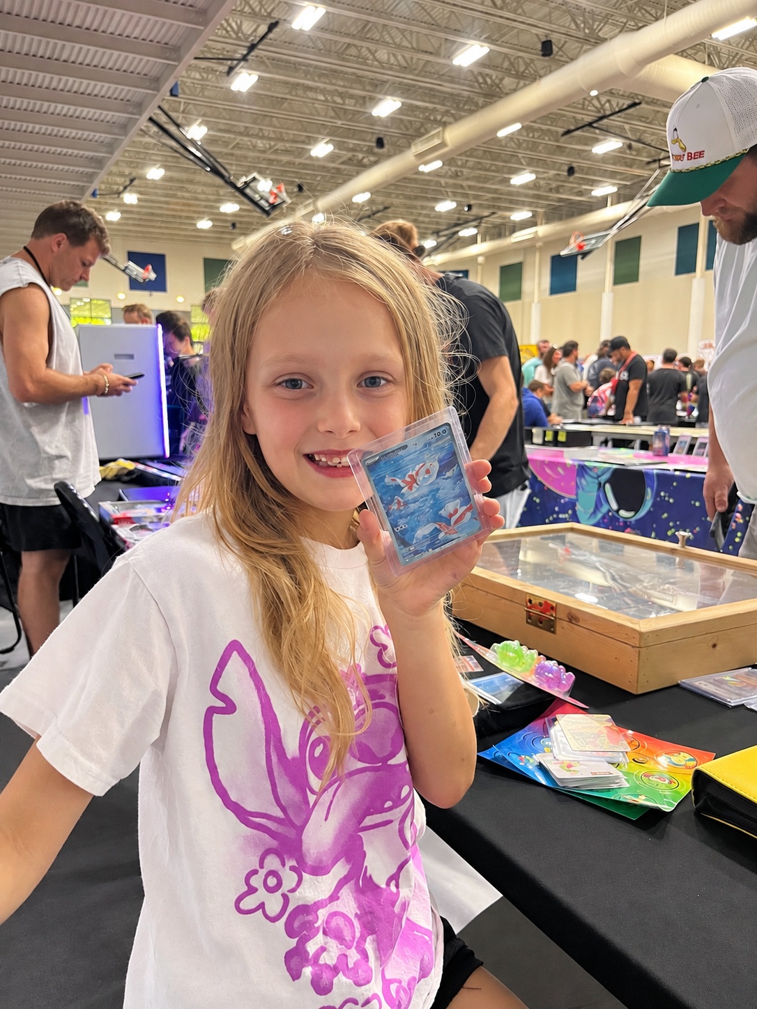 Young collector smiling with a card at a card show
